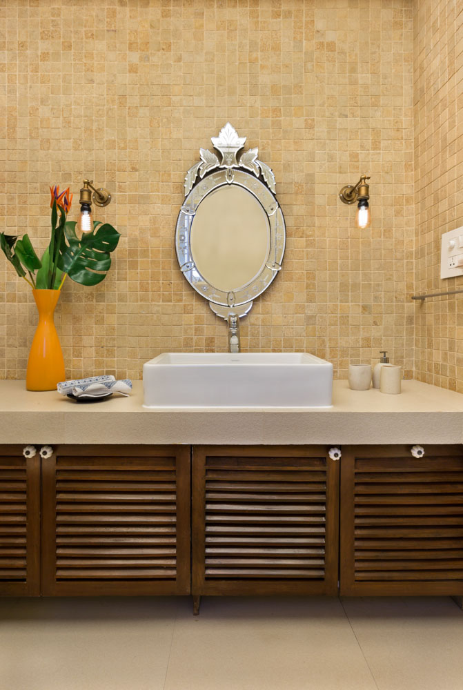 Flower arrangements in a yellow vase as décor in a brown and yellow bathroom