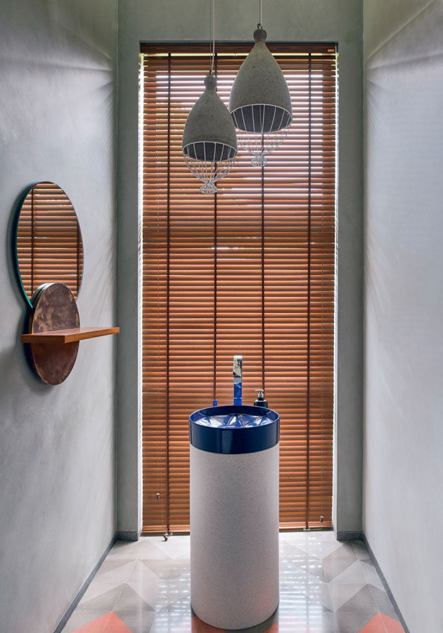 Concrete bathroom ceiling lights, grey walls and simple wood blinds in a muted bathroom