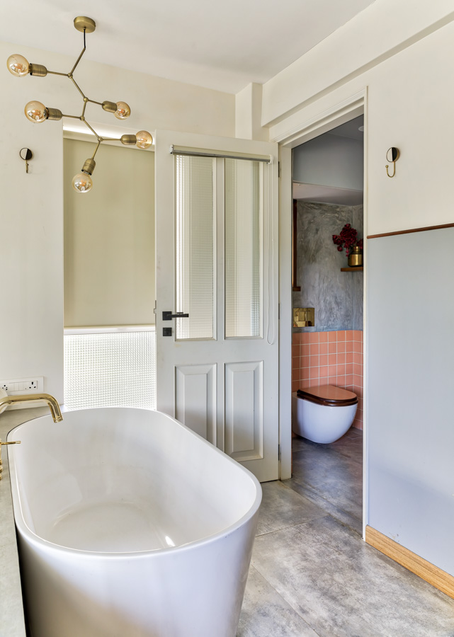 Golden bathroom lights artistically shaped in a farily simple bathroom with bathtub