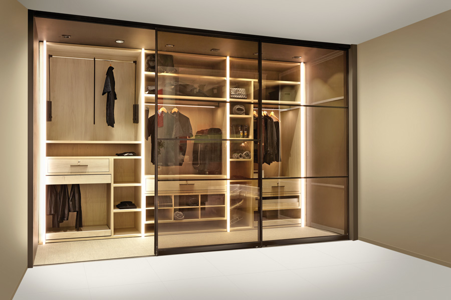 A walk-in wardrobe with clothes and other items inside