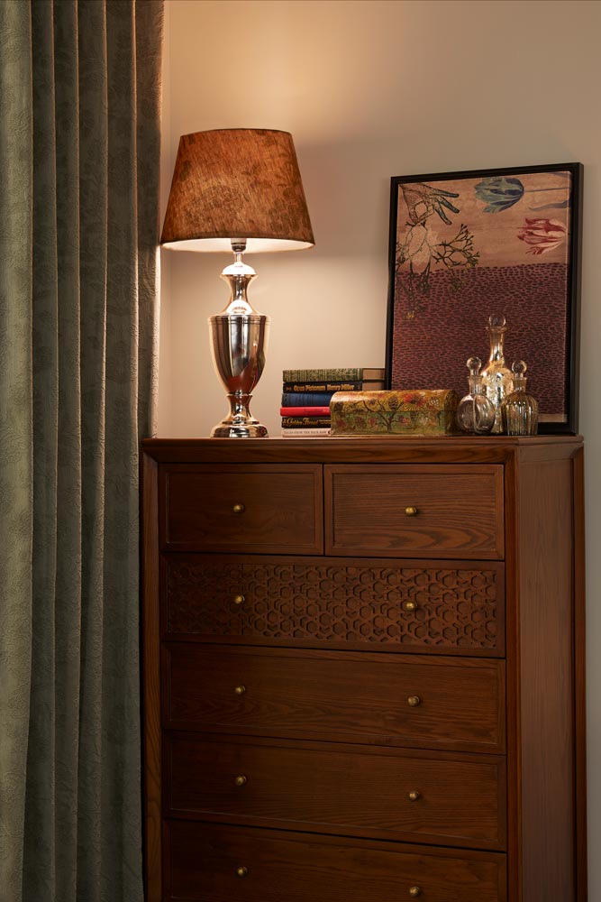 A bed side table placed next to a four poster bed