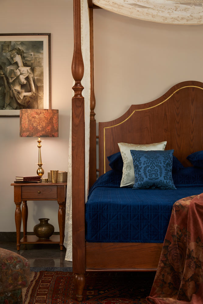 A bed side table placed next to a four poster bed