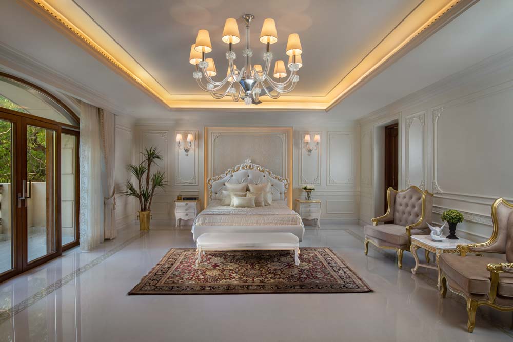 This bedroom has crown moulding paired with chandelier for ceiling design - Beautiful Homes