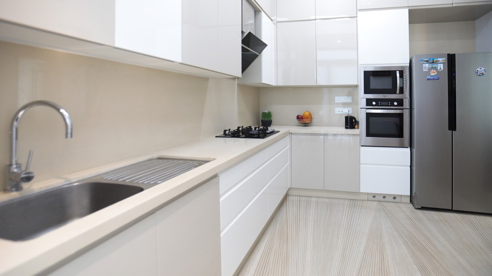 Functional kitchen interior design having creamy white & light wood finish interiors & flooring - Beautiful Homes
