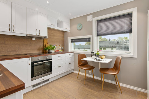 Wooden L-shaped modular kitchen with a breakfast nook near the kitchen window - Beautiful Homes