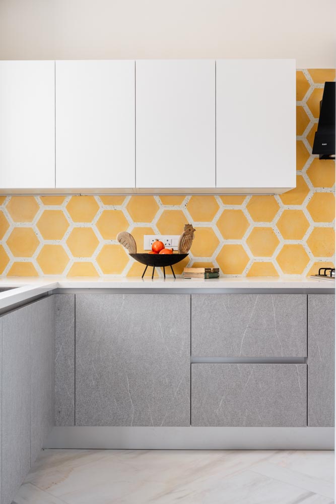 Modular kitchen with grey & yellow colour palette & a patterned backsplash design - Beautiful Homes