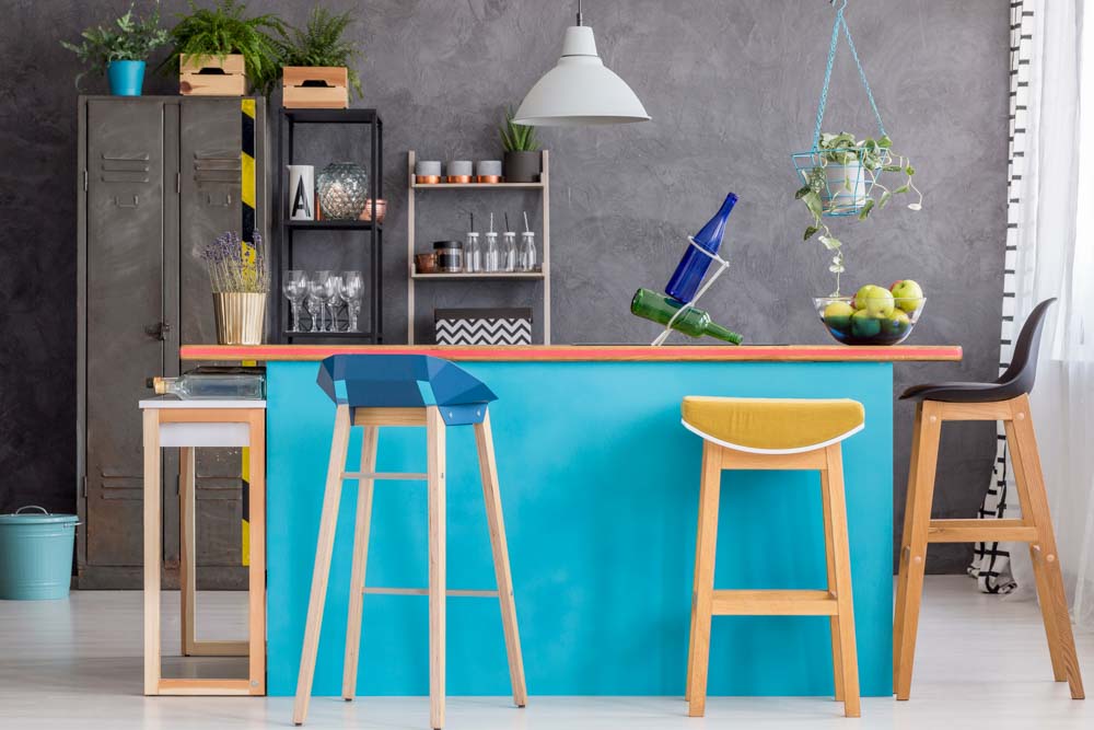 Modular kitchen interiors with concrete wall finish & bright blue kitchen island - Beautiful Homes