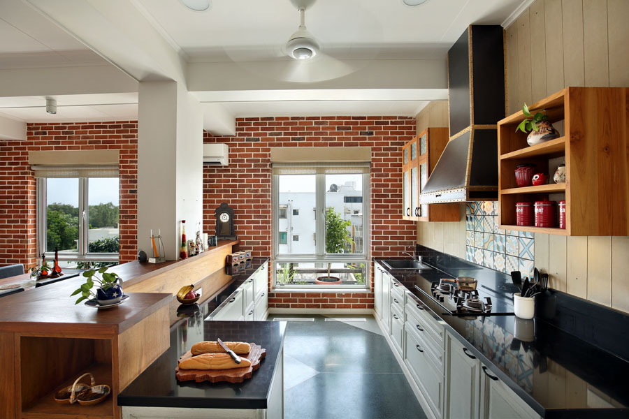 Open kitchen décor idea with large windows, red brick walls, black and white furniture and decoration in red tones - Beautiful Homes
