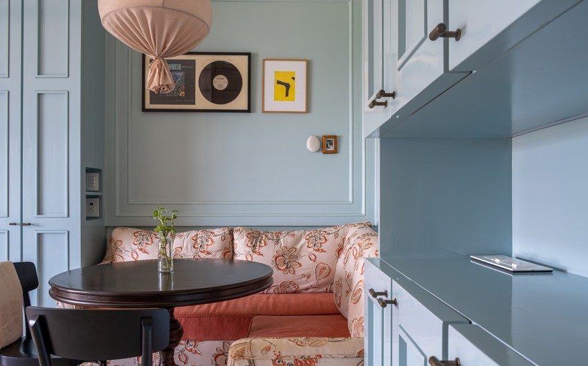 Spacious pastel blue modular kitchen having breakfast nook with round table - Beautiful Homes