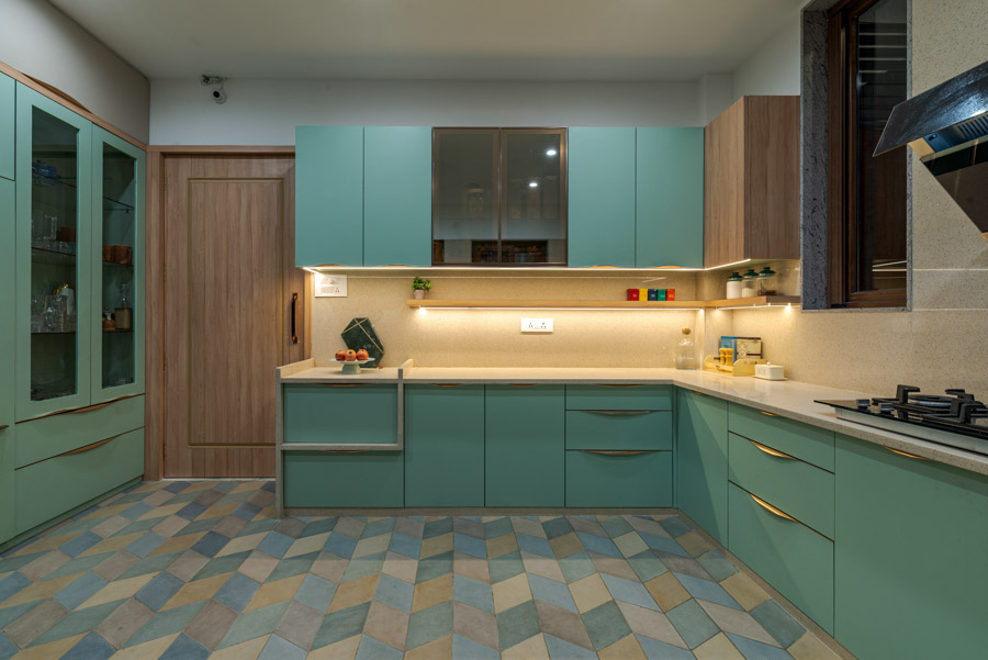Mint green retro-chic urban kitchen with gold accents, patterned floor with pastels, wooden door and cabinets