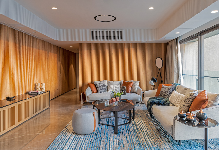 Cabin-like family room design with wooden walls, abstract-printed carpet and many colourful cushions