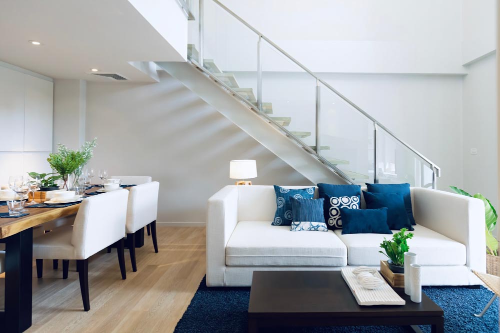 White living room with stylish stair design with glass & metallic railing - Beautiful Homes