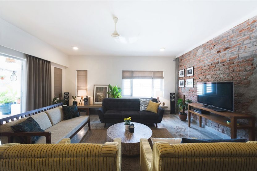 The exposed brick wall in the living room pairs well with the neutral soft furnishings - Beautiful Homes