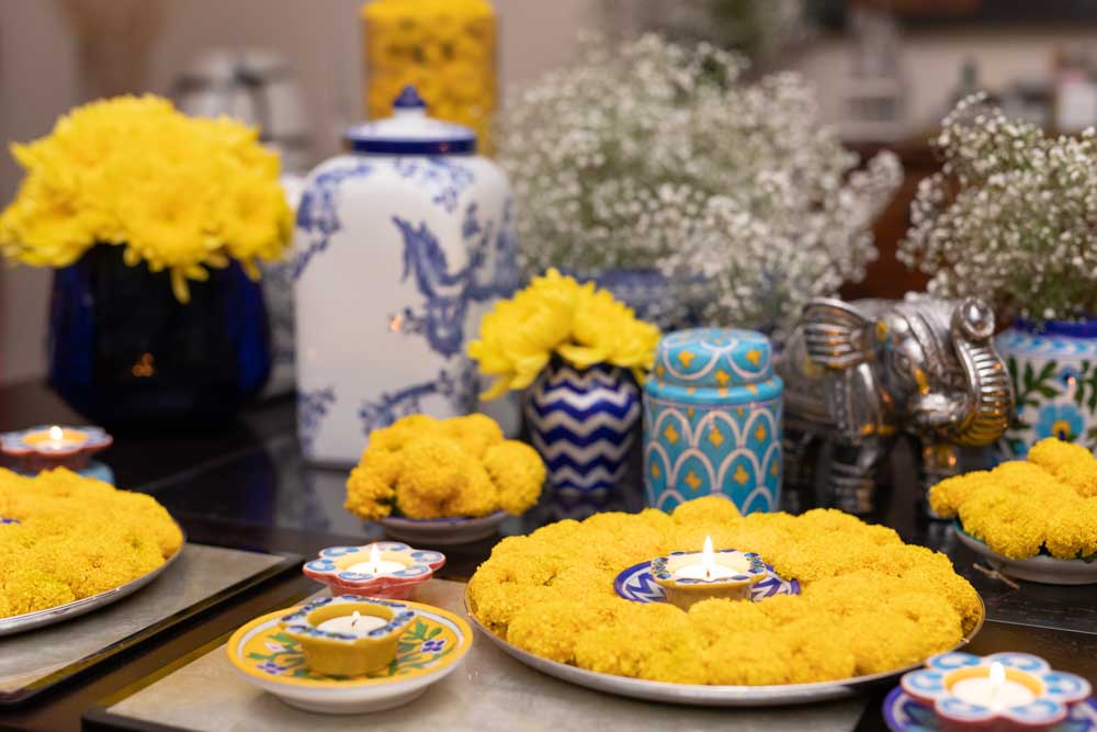  A table setting with yellow flowers and diyas