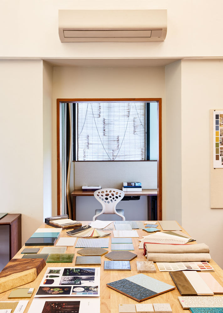 A wooden table at a interior designers office filled with materials of different kinds - Beautiful Homes