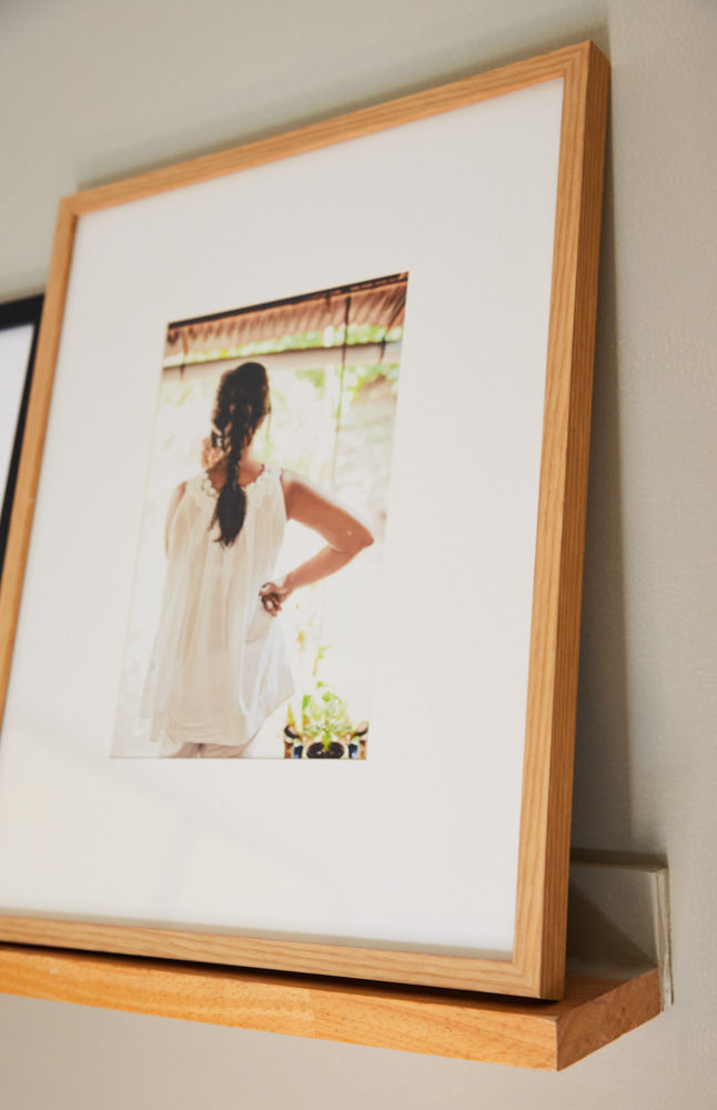 A photograph with a wooden frame placed on a small piece of wood attached to a wall - Beautiful Homes