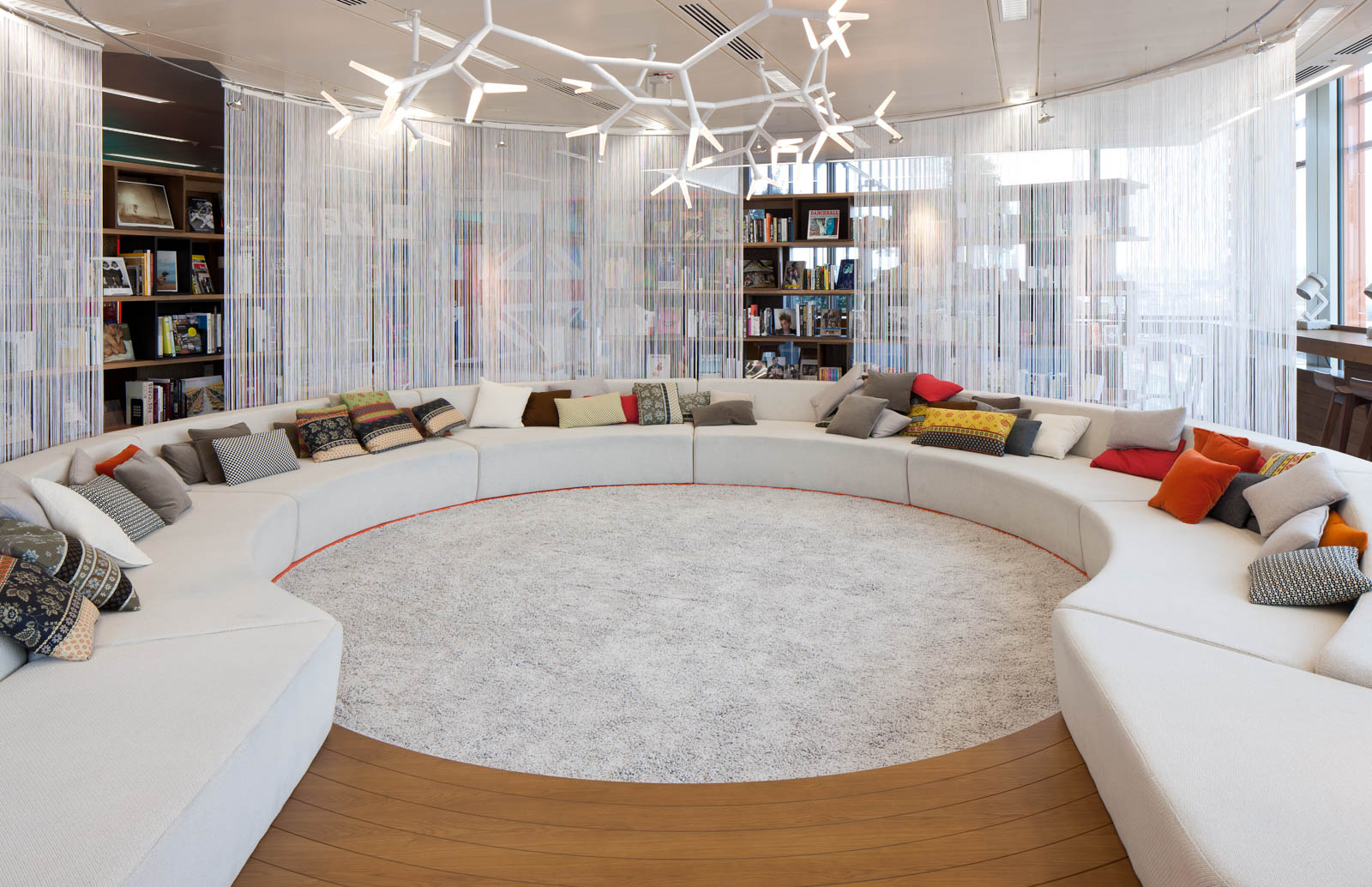 The Lala Word Library at Google's Office with an Oversized Semi-circular Sofa with Bookshelves - Beautiful Homes