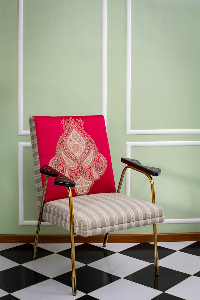 Striped armchair features brass inlay in the room interior with patterned flooring -Beautiful Homes