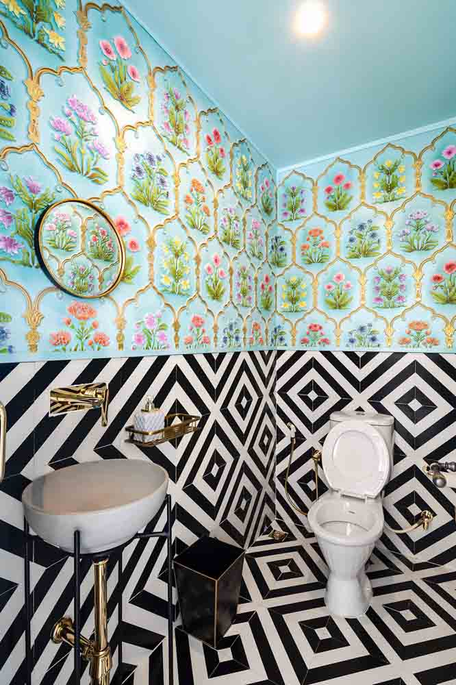 The powder room pairs geometric black & white wall & floor tiles - Beautiful Homes