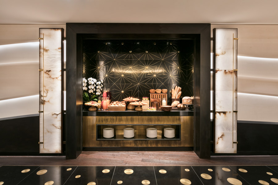 A black and gold surface behind an area where some breads and other food is kept together