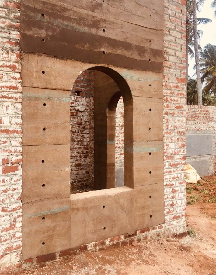 A half constructed home with exposed brick wall and concrete structure