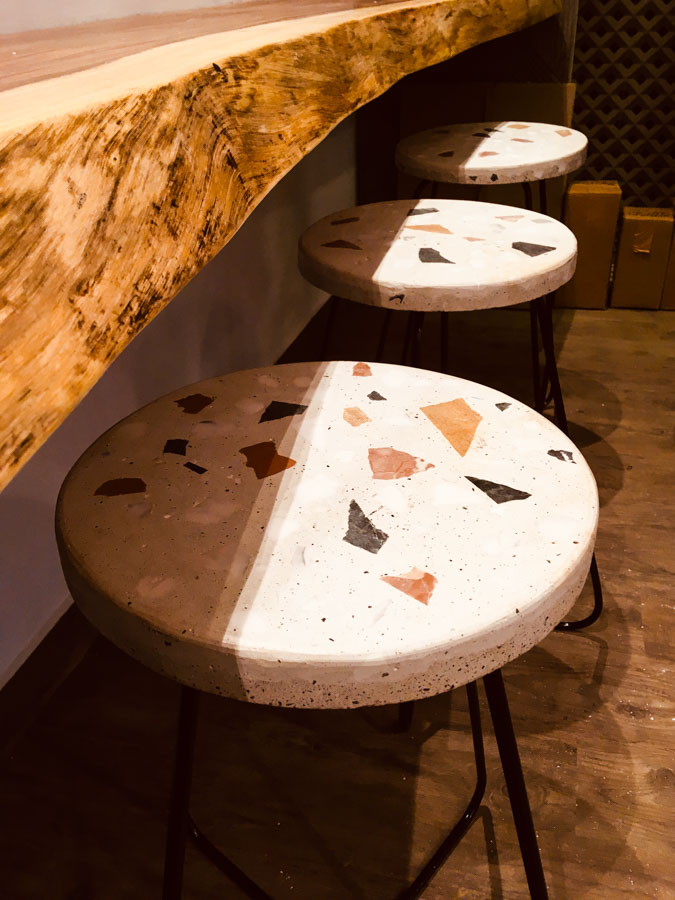 Three stools lined up next to each other with seats made of concrete