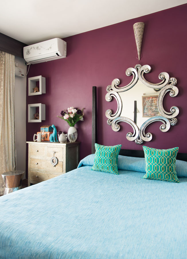 Simple Indian bedroom design played up by embroidered cushions and a flamboyant mirror frame for bedroom décor - Beautiful Homes